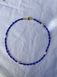 Blue and gold glass beaded necklace with oval beads, and freshwater pearls. Available at 15 inches long or 20 inches long. Blue Bead Necklace Ideas, Cute Bead Jewelry Ideas, Blue Oval Beaded Chain Necklaces, Blue Beaded Chain Necklace With Oval Beads, Blue Necklace With Oval Beads, Blue Beaded Necklaces With Oval Beads, Blue Oval Beaded Necklaces, Blue Necklace Beads, Blue Pearl Jewelry With Tiny Beads