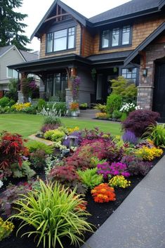 a house with lots of flowers in the front yard and landscaping on both sides of it