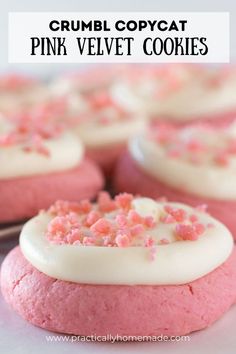 some pink velvet cookies with white frosting and sprinkles on top are shown