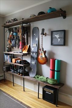 a guitar and other musical instruments are displayed on a shelf in a room with hard wood flooring