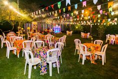 tables and chairs are set up in the grass for an outdoor party with bunting