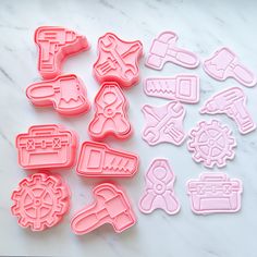 pink and white cookie cutters sitting on top of a marble counter next to each other