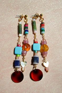 Get ready to have some fun with these playful, beaded ear jackets! Filled with bold colors, funky natural stones, and cute little details like hearts and tortoiseshell charms. On top of that these earrings are even cooler because they are like two in one! They will dangle in your ear in such a unique way. Whether you’re dressing up or keeping it casual, these earrings will add a pop of personality to any look. We created them in a rainbow color combination and in a fall inspired color palette wi 2025 Jewelry Trends, Funky Earrings Diy, Cozy Glam, Fall Tones, Hoop Charms, Stacked Earrings, Color Ways, Funky Earrings, Bold Earrings