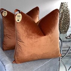 two brown pillows sitting on top of a couch