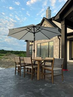 an outdoor dining table and chairs with an umbrella