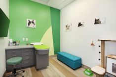 a green and white room with a blue bench in the corner next to a desk