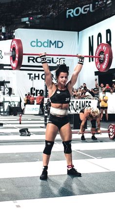 a woman lifting a barbell in a crossfit competition