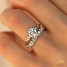 a woman's hand with a diamond ring on top of her finger and the other hand holding an engagement ring