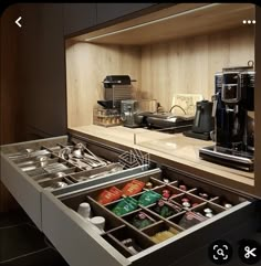 an open drawer in the middle of a counter with coffee machines and other items on it