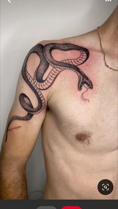 a man's chest with a snake tattoo on his left arm and the upper half of his body