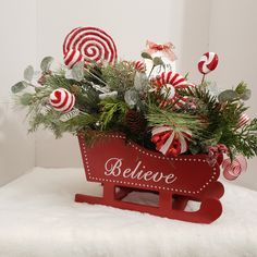 a red sleigh filled with candy canes and greenery