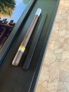 a baseball bat sitting on top of a window sill next to a glass door