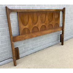 a wooden headboard against a brick wall