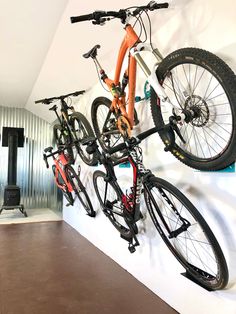 there are two bikes hanging on the wall and one is upside down in the air