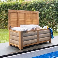 a wooden bed sitting next to a swimming pool