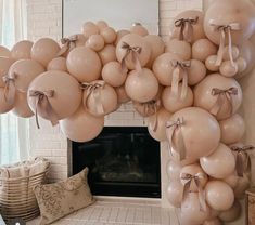 a fireplace with balloons hanging from it's mantle and a mirror in the background