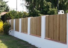 a wooden fence next to a white wall