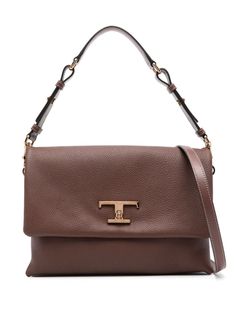 The Tod's T Timeless Tote Bag is crafted from calf leather with a pebbled texture. It features a foldover top with a T Timeless turn-lock buckle fastening, a single detachable adjustable top handle, an adjustable detachable shoulder strap, and an accordion design. The bag has a partitioned compartment, multiple internal slip pockets, and a suede lining. It also features a gold-tone logo plaque, gold-tone hardware, and an internal logo stamp. The bag comes complete with a protective dust bag. Red Valentino Shoes, Zegna Shoes, Timeless Wardrobe Staples, Valentino Shoes, Logo Stamp, Red Shoes, Beautiful Shoes, Luxury Shoes, Womens Tote Bags