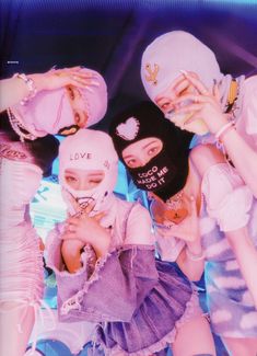 four girls wearing masks are posing for the camera