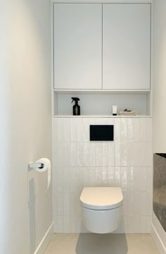 a white toilet sitting in a bathroom next to a cabinet