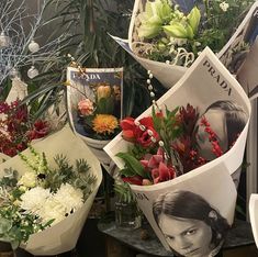 a bunch of flowers sitting on top of a table next to a vase filled with flowers