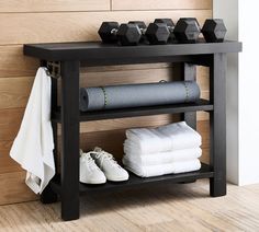 there is a shelf with towels and dumbbells on it next to a pair of shoes