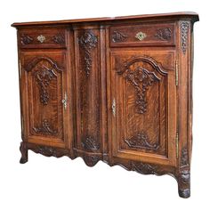 an old wooden sideboard with carvings on the doors and drawer pulls, isolated against a white background