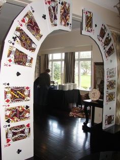 an arch made out of playing cards in a living room with hardwood floors and windows