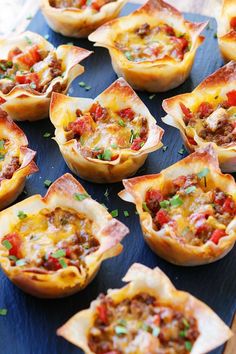 small cups filled with food sitting on top of a blue tray next to a wooden table