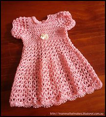 a pink crocheted baby dress sitting on top of a wooden floor with the words wendy gown written below it