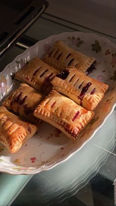 several pastries sitting on a plate in front of a toaster oven