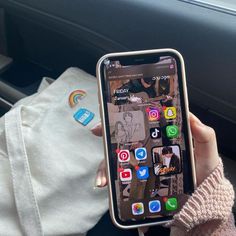 a person holding up an iphone in their hand with the screen showing icons on it