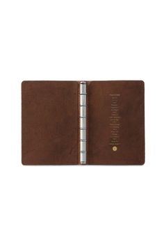 a brown leather book with writing on the front and inside pages, open to reveal a page