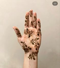 a woman's hand with hendix on it and flowers painted on the palm