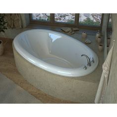 a large white bath tub sitting next to a window