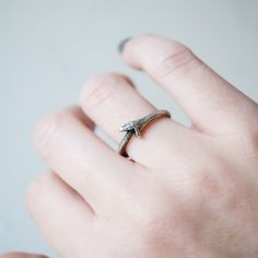 The circular snake, Ouroboros, is an ancient symbol for the infinite cycle of destruction and rebirth. Anthony Lent's take on this universal theme is entrancing in oxidized sterling silver with piercing diamond eyes. This ring cannot be resized. Stones: Two White Diamonds, Total .02tcwMetal: Oxidized Sterling SilverMeasurements: Band height: 2.2mm, Band with: 2.5mm Size 6.75 in stock Shipping and Delivery: IN STOCK items will ship within 2 business days Sizes not In Stock will be MADE TO ORDER P