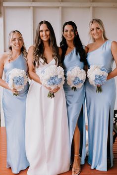 the bridesmaids are all wearing blue dresses and holding bouquets in their hands