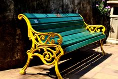 a green and yellow bench sitting next to a wall