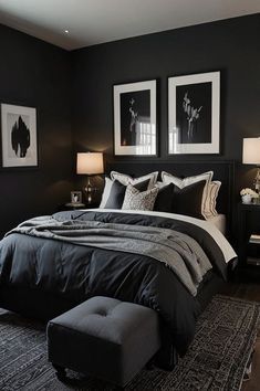 a black and white bedroom with two pictures on the wall above the bed, along with a footstool