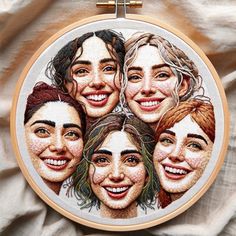 a close up of a embroidery on a piece of cloth with four women smiling together