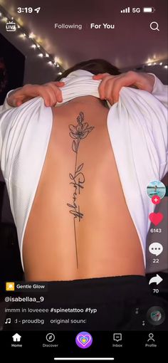 the back of a woman's body with a flower tattoo on her left side