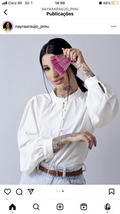 a woman with tattoos holding a pink comb