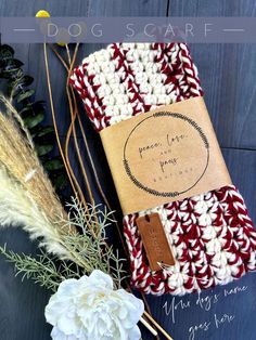 a crocheted book cover sitting on top of a wooden table next to flowers