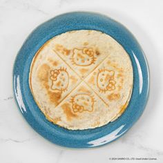 a flatbread with hello kitty on it sitting on a blue plate