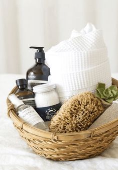 a wicker basket filled with personal care items on top of a white bed sheet