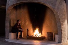 a man sitting in front of a fire place