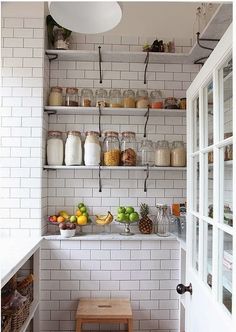 a kitchen with white brick walls and open shelving