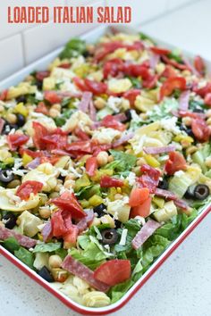 a salad with tomatoes, olives, lettuce and black olives in it