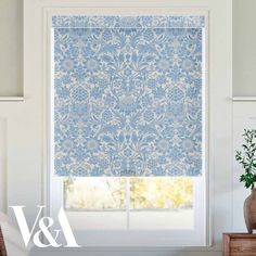 a blue and white roman blind in front of a window with an ornate pattern on it