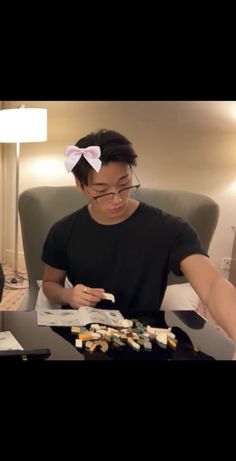 a man sitting at a table with sushi and chopsticks in front of him